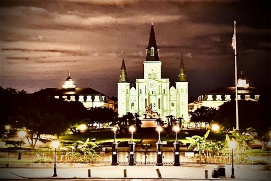 St. Louis Cathedral glowing over haunted Jackson Square at night.