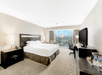 One king bed, flat-screen TV, and a work desk in a guest room.