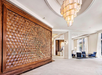 Hotel lobby featuring a striking geometric wood panel with a carved 'Liberty Tree' design, elegant lighting fixtures, and modern seating areas with natural light streaming through large windows.