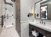 Marble bathroom with vanity area, walk-in shower, and fresh towels.