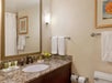 Granite-top bathroom vanity with complimentary toiletries inside a private bathroom.