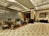 Spacious hotel lobby with modern decor, featuring seating areas, a fireplace, checkered tile flooring, and wall art, illuminated by overhead lighting.