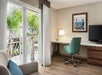 Desk, TV, seating area, and view of the pool.
