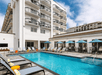 Outdoor pool with sun loungers at Hilton Garden Inn Cocoa Beach-Oceanfront, FL.