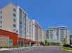 View looking up at the Hilton Garden Inn Columbus Easton with no cars in the parking lot on a bright sunny day.