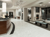 The lobby of the Hilton Garden Inn Denver Downtown with the curved dark brown front desk on the left and sitting areas on the right.