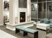 A sitting area with a couch, chair, bench, and ottoman in front of a fireplace in the lobby of the Hilton Garden Inn Denver Downtown.
