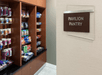 A market area with brown shelves full of snacks and a plaque on the door reading "Pavilion Pantry" at the Hilton Garden Inn Denver Downtown.