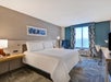One king bed, work desk and a flat-screen TV inside a guest room.