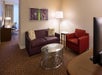 A separate seating area with sofa, flat-screen TV and a glass center table.