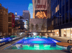 Outdoor pool with sun loungers and view of the city.