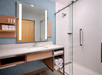 Vanity mirror, shower and a fresh towels inside a private bathroom.