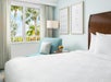 One King bed and a chair inside a guest room.
