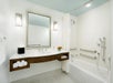 Accessible bathtub with grab bars and sink in a guest bathroom.
