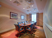 Meeting room equipped with a long table and office chairs.