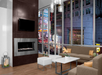 Modern lounge area with a fireplace, TV, and seating, featuring large windows overlooking a brightly lit cityscape at night.