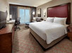 One king bed, work desk, and soft seating inside a guest room.