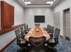 Meeting facility with a large table, flat-screen TV and chairs.