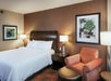One king bed, bedside lamps, and seating area in a guest room.