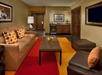 Seating area with soft seating and a flat-screen TV inside a guest room.