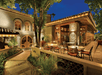 A relaxing outdoor patio with tables and chairs surrounded by trees and plants.