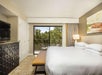 One King bed, a balcony, and a flat screen TV inside a guest room.