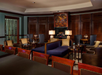 Elegant hotel lounge with plush seating, wooden accents, a brick fireplace, and ambient lighting.