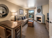 Living area with a comfortable sofa, a private balcony, dining table and a fireplace.