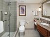 Guest bathroom with fresh towels, toilet and a glass-enclosed shower.
