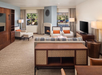 A spacious and luxuriously designed living area complete with sofas, fireplace, flat-screen TV and windows with a view.