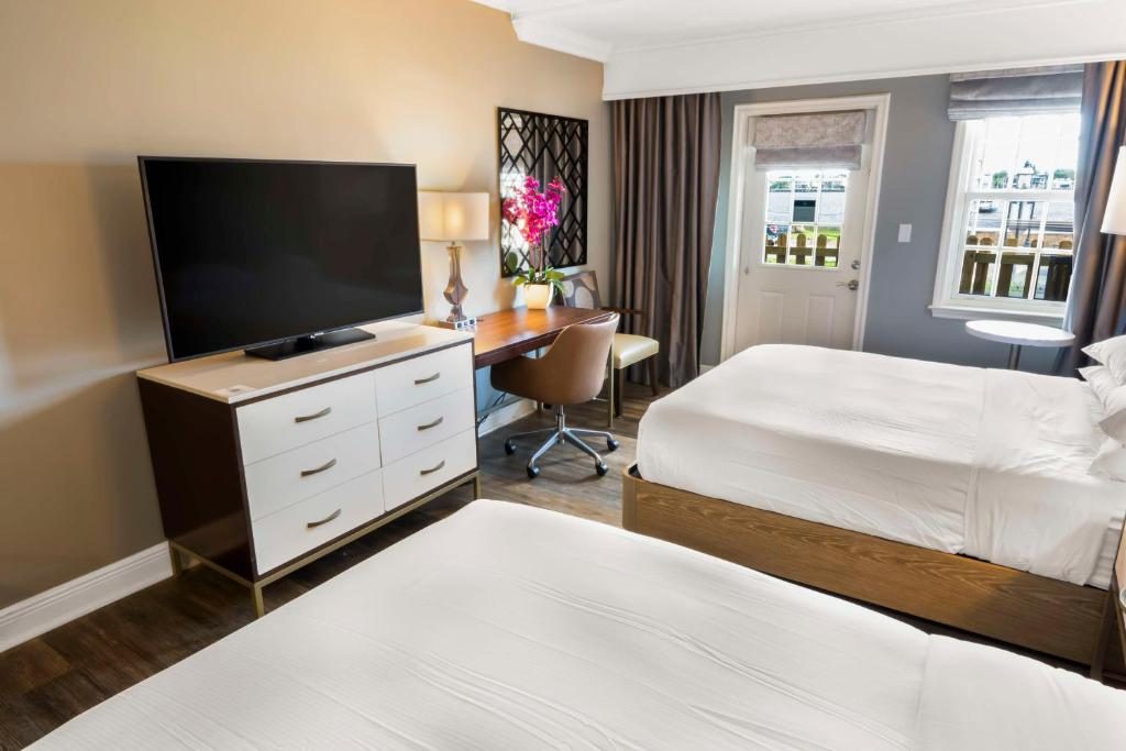 Two queen beds, work area, a balcony, and a TV