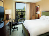 One bed, work desk & chair, and balcony inside a guest room.