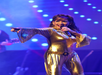 A woman stands on stage, singing while directing her gaze towards the audience








