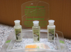 Hotel toiletries set with coconut and lime verbena body lotion, volumizing shampoo, and volumizing conditioner displayed on a bathroom counter.