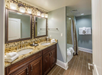 Private bathroom with double vanity, bathtub, and fresh towels.