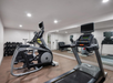 Fitness center with treadmill, elliptical trainer, free weights, and other gym equipment.