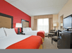 Guest room with two queen beds, flat-screen TV, desk, and microwave.