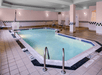 Refreshing indoor pool with poolside chairs.
