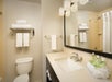 Vanity mirror, fresh towels, and complimentary toiletries inside a private bathroom.
