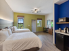 A well-equipped room featuring two queen beds, a work desk, and essential appliances for a seamless stay.