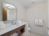 The bathroom includes essential amenities with a modern sink, fresh towels, and a convenient toilet.