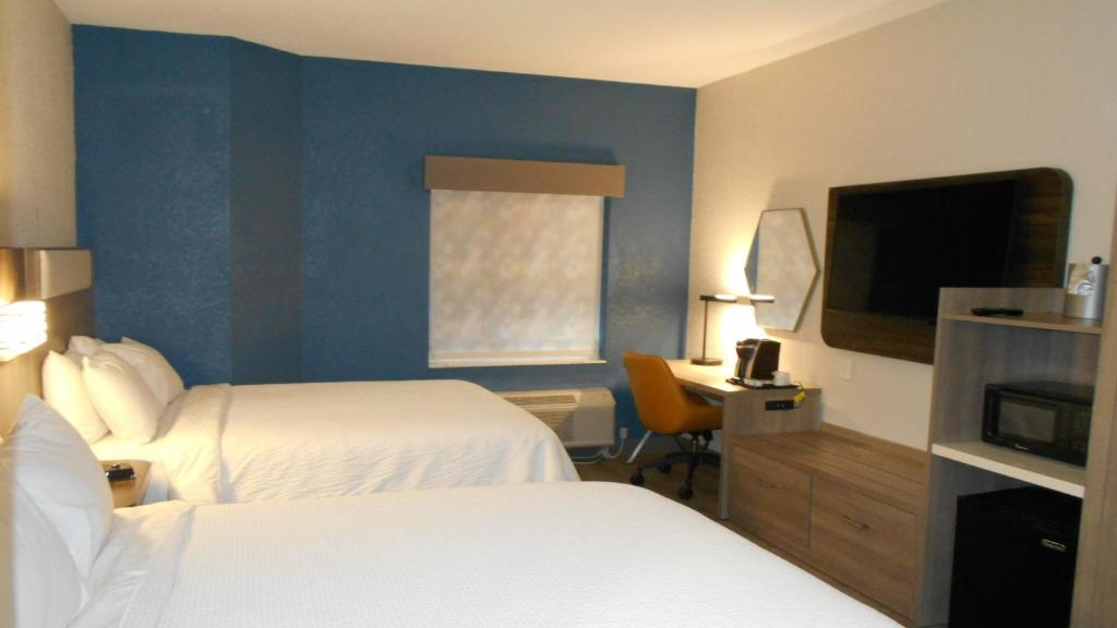 Two queen beds, work area, mini fridge, microwave, and a wall-mounted TV