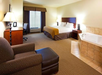 2 Queen beds and a seating area inside a guest room.