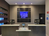 Hotel reception area with two front desks, a small display screen, and a logo on the wall behind.