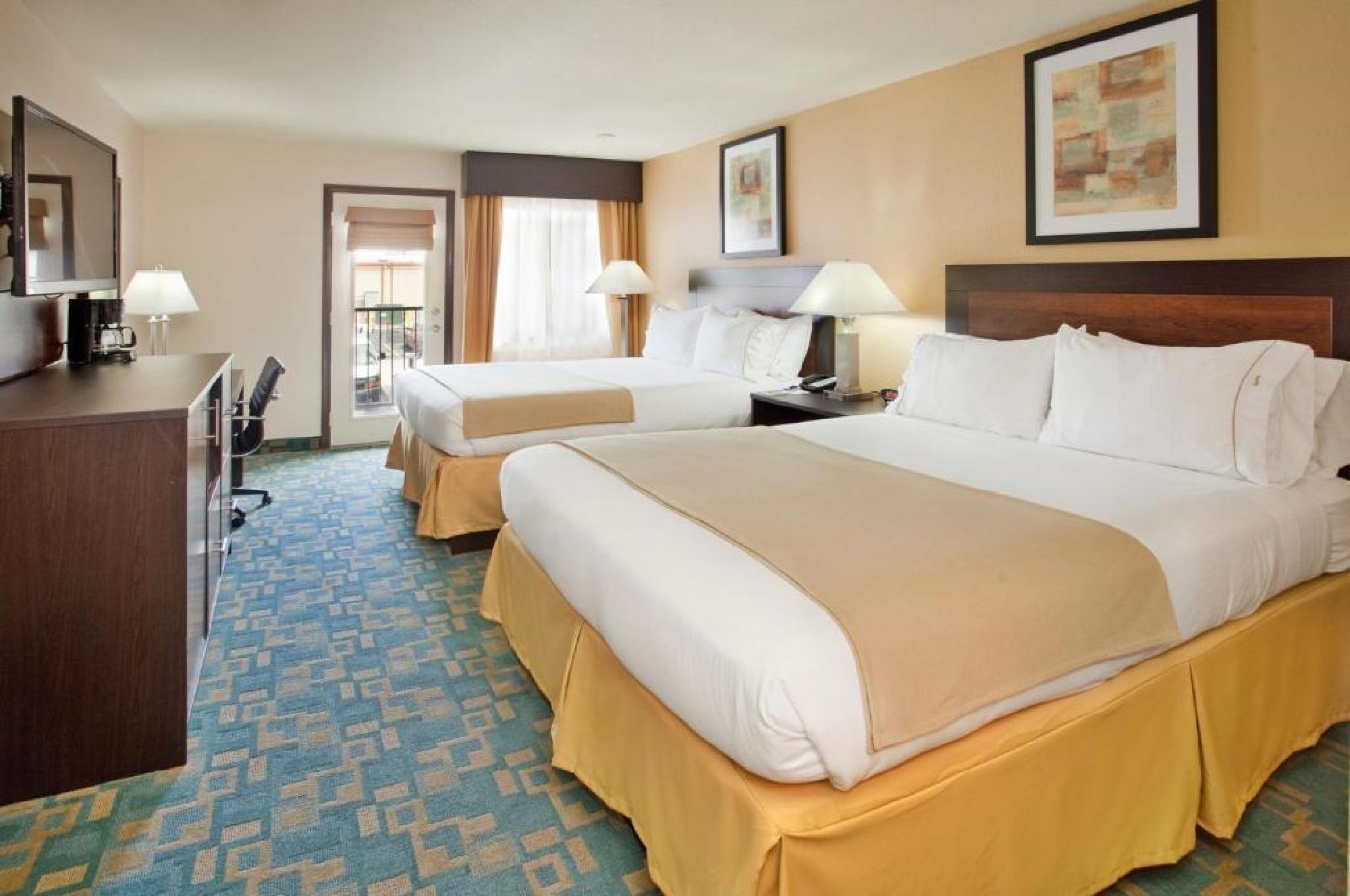 Guest room with two beds, flat-screen TV, work desk and chair.