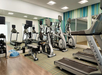 Fitness center with treadmills, elliptical trainers, exercise bike, and free weights.