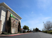 Holiday Inn Express building with flags, next to an empty parking lot under a clear blue sky.