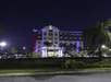The front exterior of the  Holiday Inn Express & Suites with blue lights illuminating the front at night in Orlando, Florida.