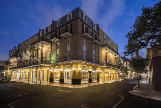 Holiday Inn French Quarter-Chateau LeMoyne's exterior illuminated by bright lights at night.