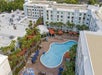 Aerial view of the hotel and the pool area with plenty of lounge chairs, a kids' splash pad and pool cabanas.